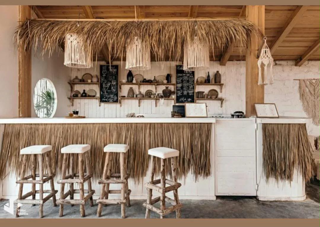 Tropical boho bar with thatch roof and wooden stools